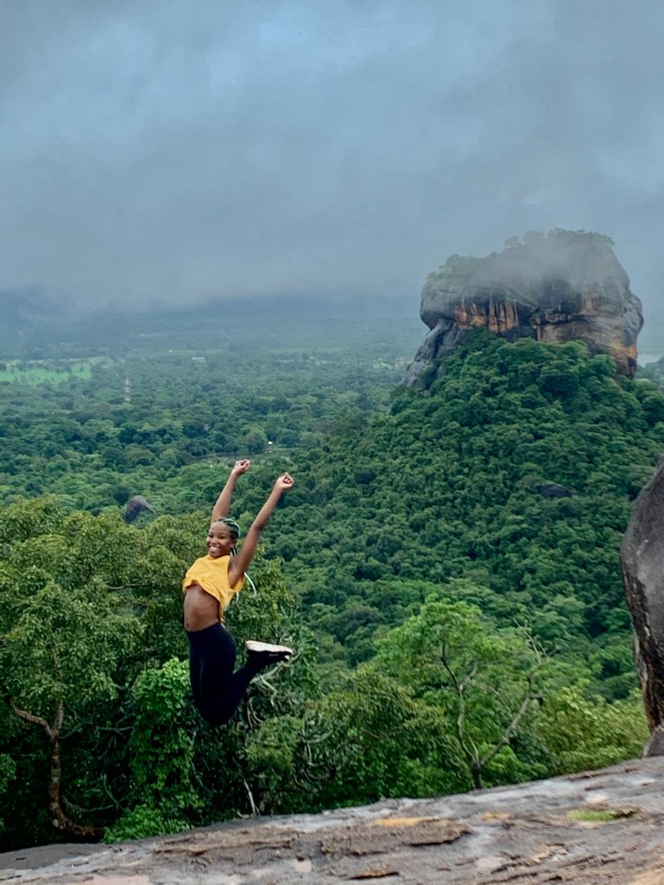 Voyageuse exaltée face au rocher du lion de Sigiriya, depuis le sommet du Pidurangala